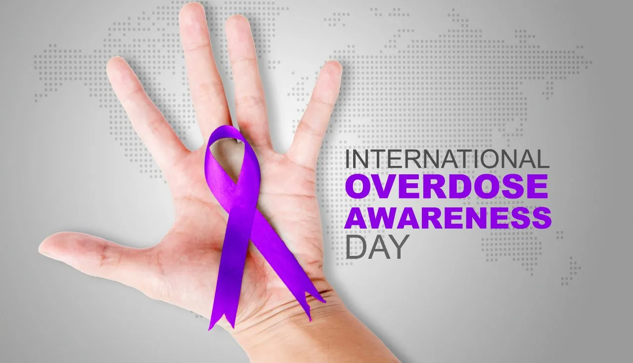 hand with purple ribbon honoring overdose awareness day